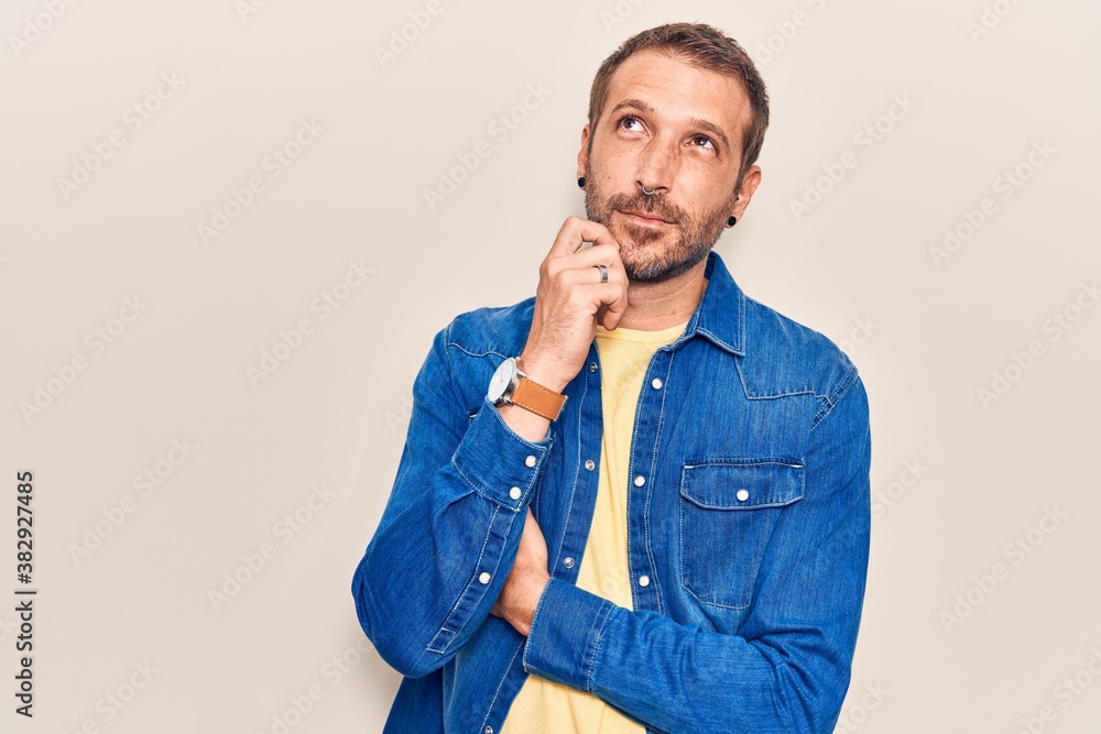 Young handsome man wearing casual clothes serious face thinking about question with hand on chin, thoughtful about confusing idea Young handsome man wearing casual clothes serious face thinking about question with hand on chin, thoughtful about confusing idea