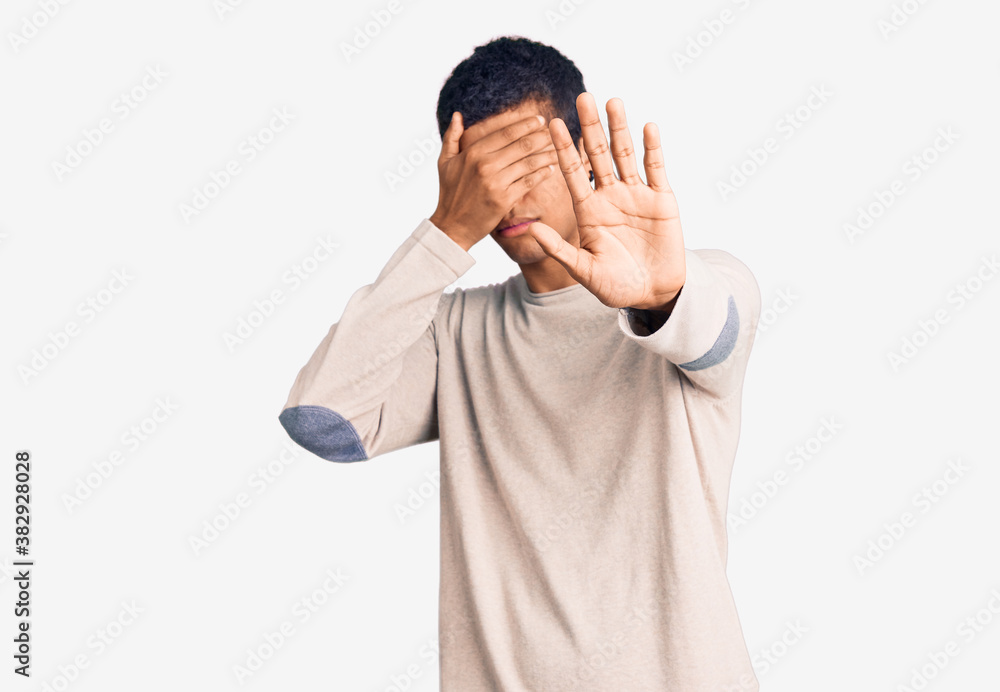 Young african amercian man wearing casual clothes covering eyes with hands and doing stop gesture with sad and fear expression. embarrassed and negative concept. Young african amercian man wearing casual clothes covering eyes with hands and doing stop gesture with sad and fear expression. embarrassed and negative concept.