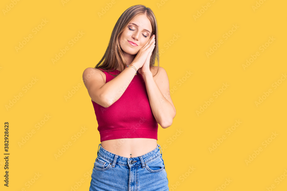 Fototapeta premium Young beautiful blonde woman wearing elegant summer shirt sleeping tired dreaming and posing with hands together while smiling with closed eyes.