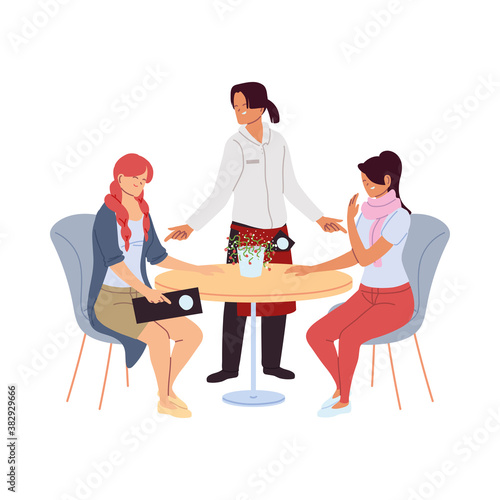 women in restaurant and waiter in uniform taking the order photo