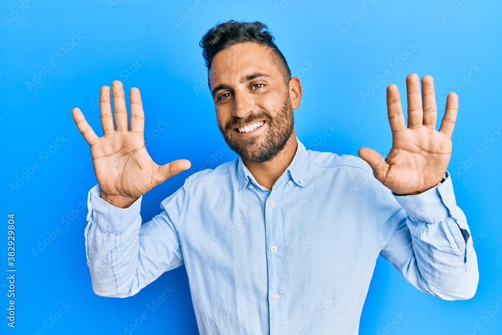 Handsome man with beard wearing casual clothes showing and pointing up with fingers number ten while smiling confident and happy. Handsome man with beard wearing casual clothes showing and pointing up with fingers number ten while smiling confident and happy.