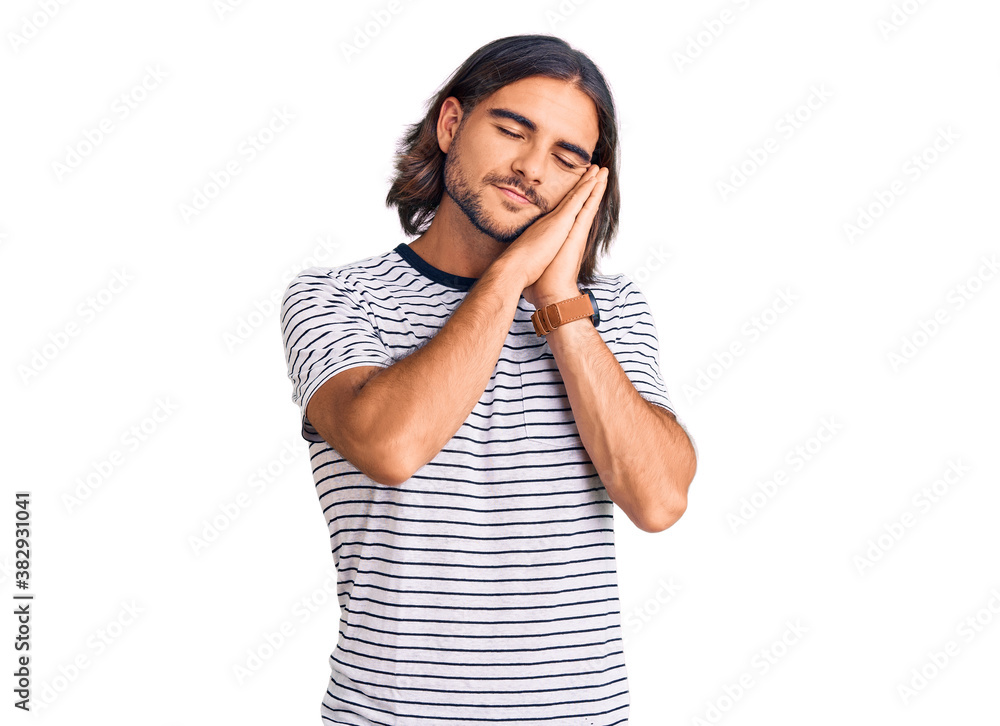 Young handsome man wearing casual clothes sleeping tired dreaming and posing with hands together while smiling with closed eyes. Young handsome man wearing casual clothes sleeping tired dreaming and posing with hands together while smiling with closed eyes.