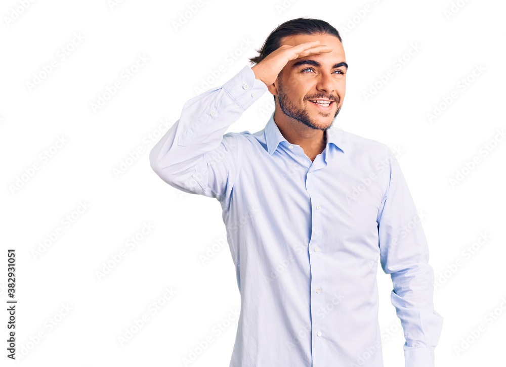 Young handsome man wearing business clothes very happy and smiling looking far away with hand over head. searching concept. Young handsome man wearing business clothes very happy and smiling looking far away with hand over head. searching concept.