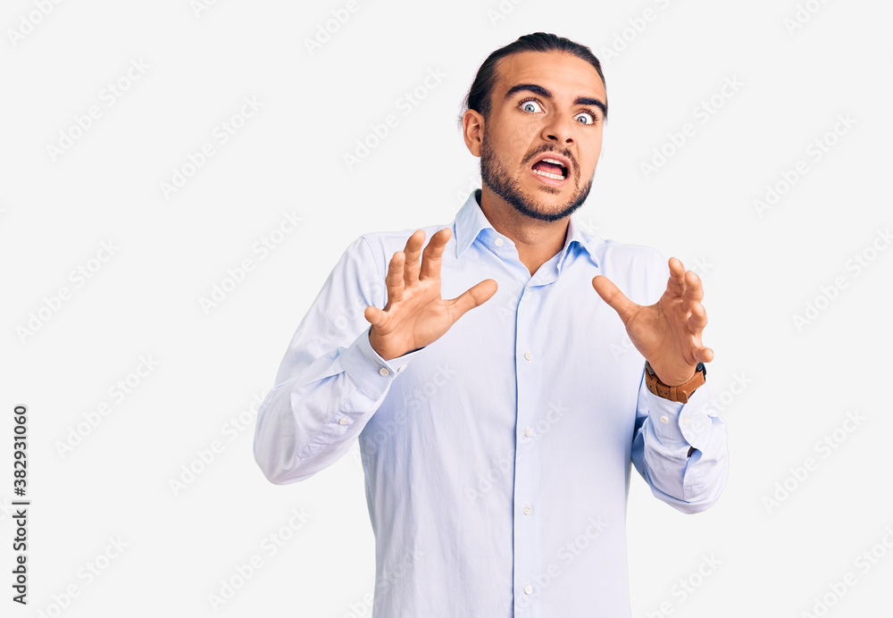 Young handsome man wearing business clothes afraid and terrified with fear expression stop gesture with hands, shouting in shock. panic concept. Young handsome man wearing business clothes afraid and terrified with fear expression stop gesture with hands, shouting in shock. panic concept.