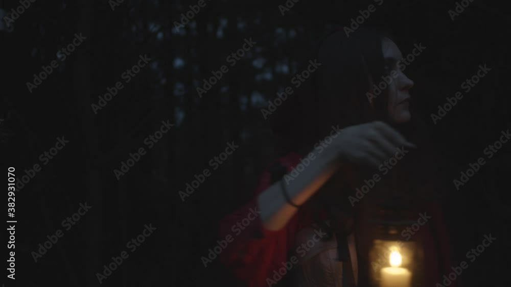 Red riding hood in dark woods with lantern, slow motion Red riding hood in dark woods with lantern, slow motion