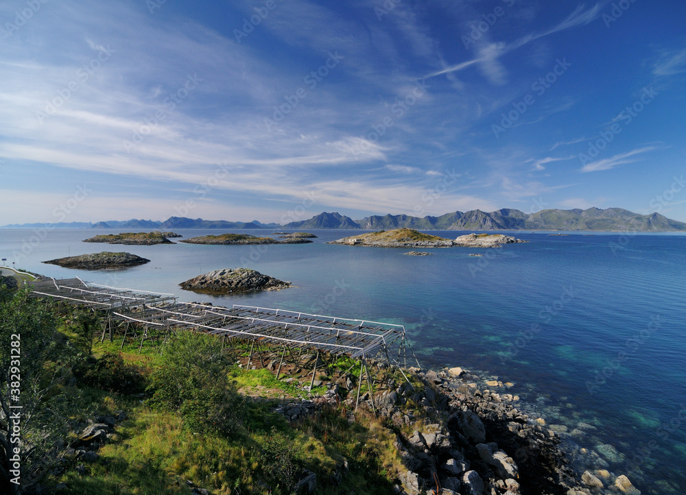 Drying Racks For Stockfish On The Shore Of Lofoten Island Austvagoy On A Sunny Summer Day With A Clear Blue Sky And A Few Clouds