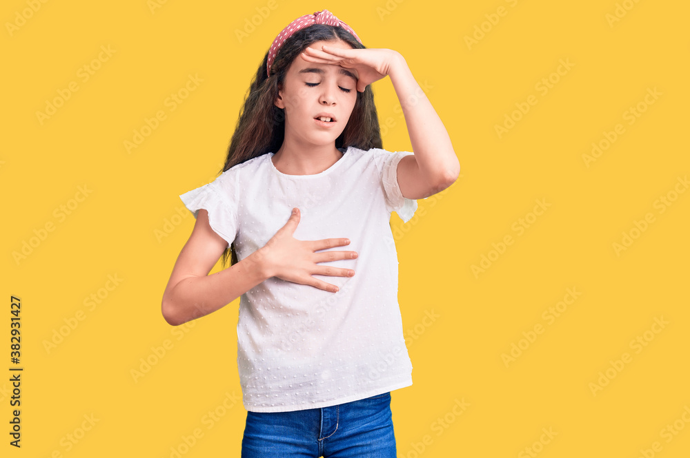 Cute hispanic child girl wearing casual white tshirt touching forehead for illness and fever, flu and cold, virus sick Cute hispanic child girl wearing casual white tshirt touching forehead for illness and fever, flu and cold, virus sick