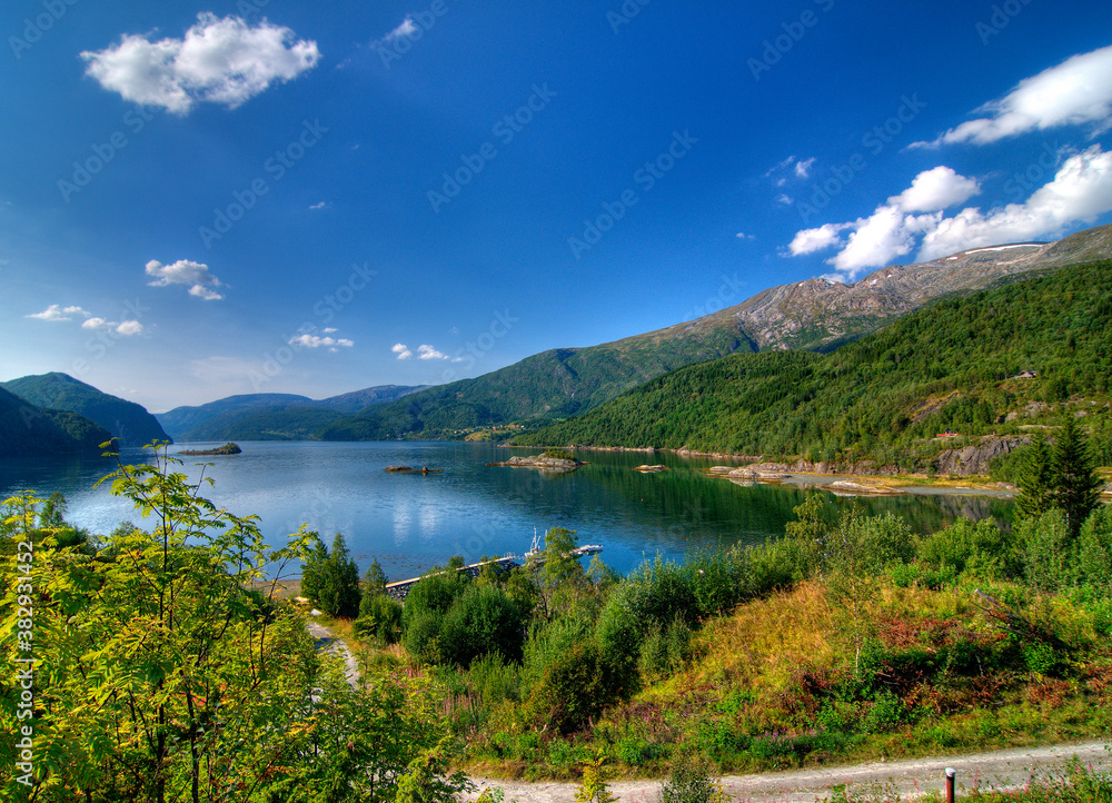 View To Leirfjord At Baggfossen Falls On A Sunny Summer Day With A Clear Blue Sky And A Few Clouds