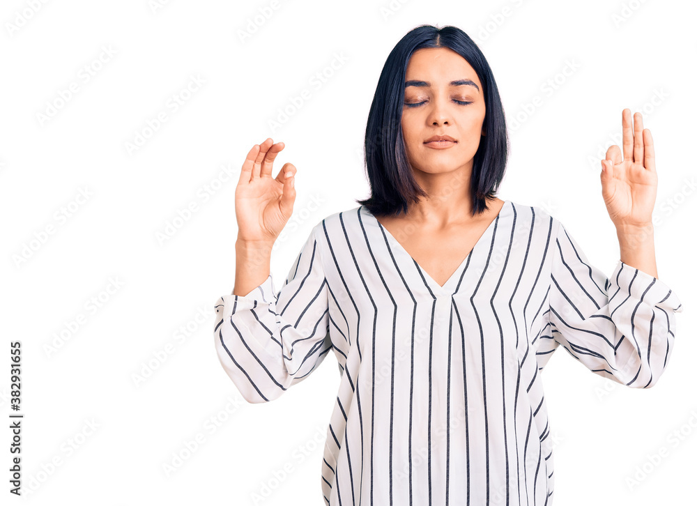 Young beautiful latin woman wearing casual clothes relax and smiling with eyes closed doing meditation gesture with fingers. yoga concept. Young beautiful latin woman wearing casual clothes relax and smiling with eyes closed doing meditation gesture with fingers. yoga concept.