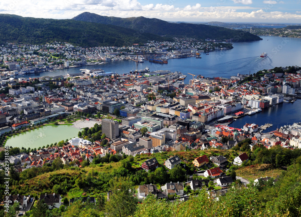 Spectacular View From Mount Floyen To Downtown And The Harbour Of Bergen On A Sunny Summer Day With A Clear Blue Sky And A Few Clouds
