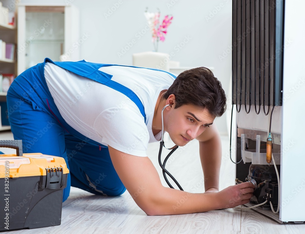 Obraz premium Repairman contractor repairing fridge in DIY concept