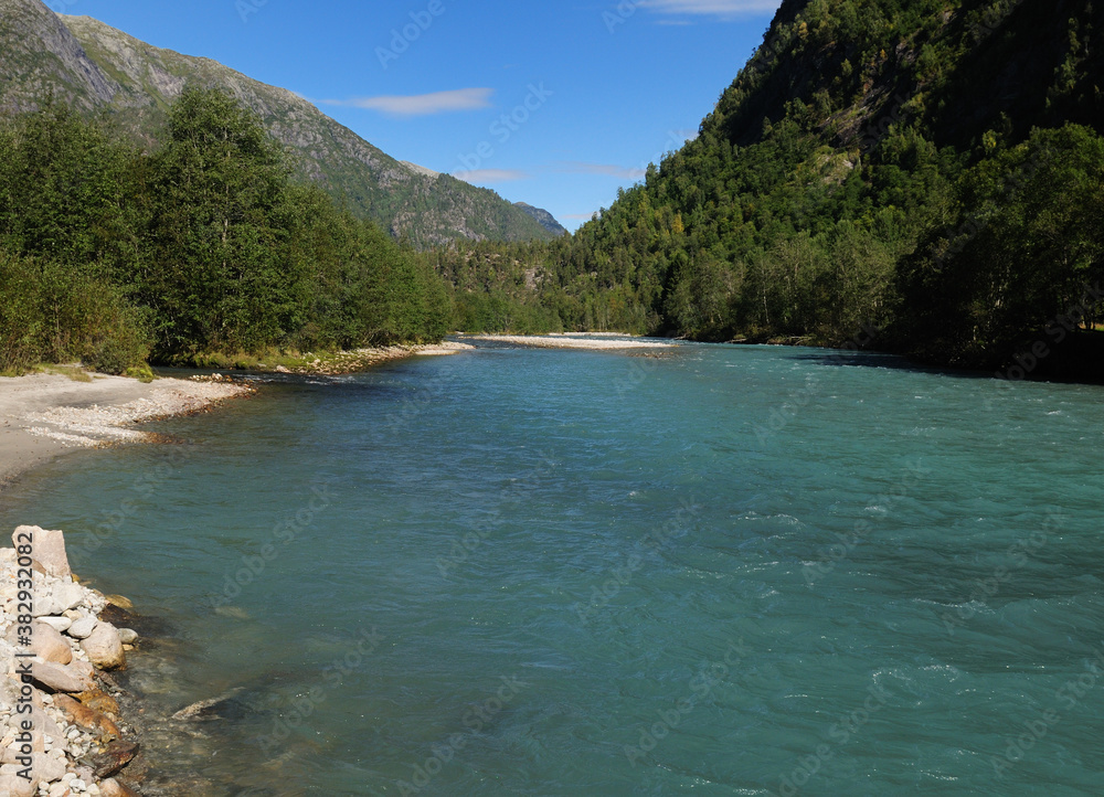 The Beautiful Turquoise Water Of The Lustrafjord On A Sunny Summer Day With A Clear Blue Sky And A Few Clouds