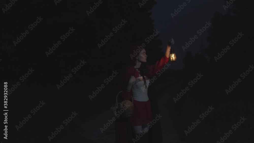 Red riding hood in dark woods with lantern, slow motion Red riding hood in dark woods with lantern, slow motion