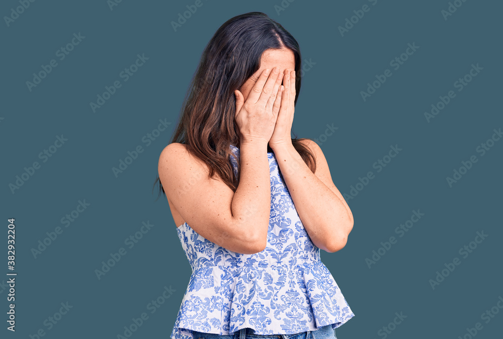 Young beautiful brunette woman wearing casual t-shirt with sad expression covering face with hands while crying. depression concept. Young beautiful brunette woman wearing casual t-shirt with sad expression covering face with hands while crying. depression concept.