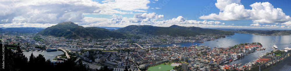 Spectacular Panorama View From Mount Floyen To Downtown And The Harbour Of Bergen On A Sunny Summer Day With A Clear Blue Sky And A Few Clouds
