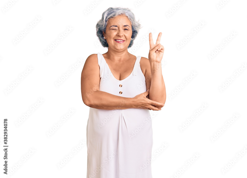 Senior woman with gray hair wearing casual clothes smiling with happy face winking at the camera doing victory sign. number two. Senior woman with gray hair wearing casual clothes smiling with happy face winking at the camera doing victory sign. number two.