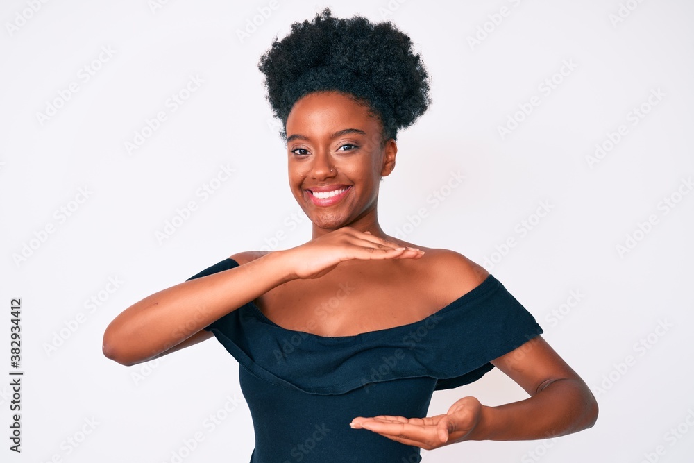 Young african american woman wearing casual clothes gesturing with hands showing big and large size sign, measure symbol. smiling looking at the camera. measuring concept. Young african american woman wearing casual clothes gesturing with hands showing big and large size sign, measure symbol. smiling looking at the camera. measuring concept.