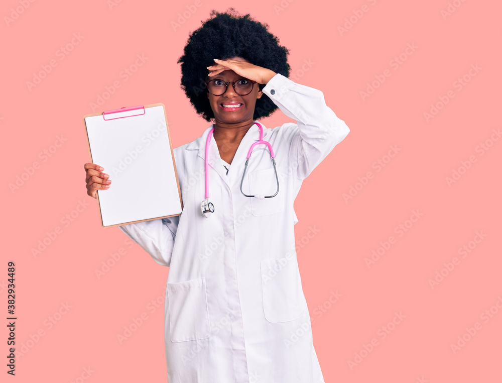 Young african american woman wearing doctor stethoscope holding clipboard stressed and frustrated with hand on head, surprised and angry face