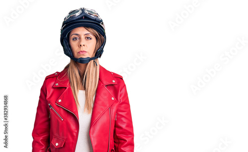 Young beautiful woman wearing motorcycle helmet with serious expression on face. simple and natural looking at the camera. © Krakenimages.com