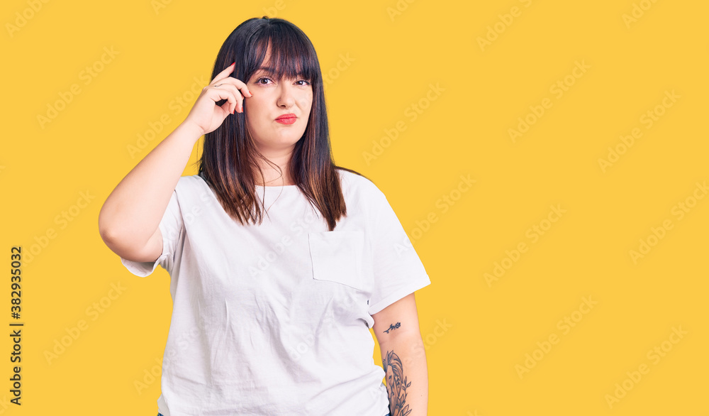Young plus size woman wearing casual clothes worried and stressed about a problem with hand on forehead, nervous and anxious for crisis Young plus size woman wearing casual clothes worried and stressed about a problem with hand on forehead, nervous and anxious for crisis