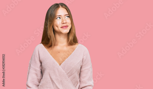 Photos Beautiful blonde woman wearing casual winter pink sweater smiling looking to the side and staring away thinking
