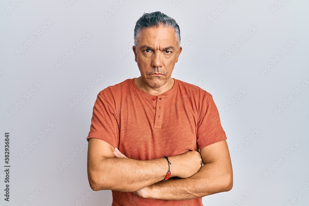 Handsome middle age mature man wearing casual clothes skeptic and nervous, disapproving expression on face with crossed arms. negative person. Handsome middle age mature man wearing casual clothes skeptic and nervous, disapproving expression on face with crossed arms. negative person.