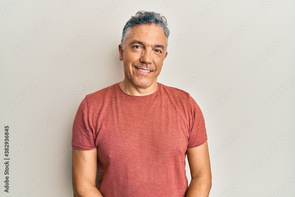 Handsome middle age mature man wearing casual clothes with a happy and cool smile on face. lucky person.