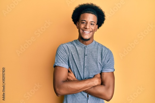 African american man with afro hair wearing casual clothes happy face smiling with crossed arms looking at the camera. positive person.