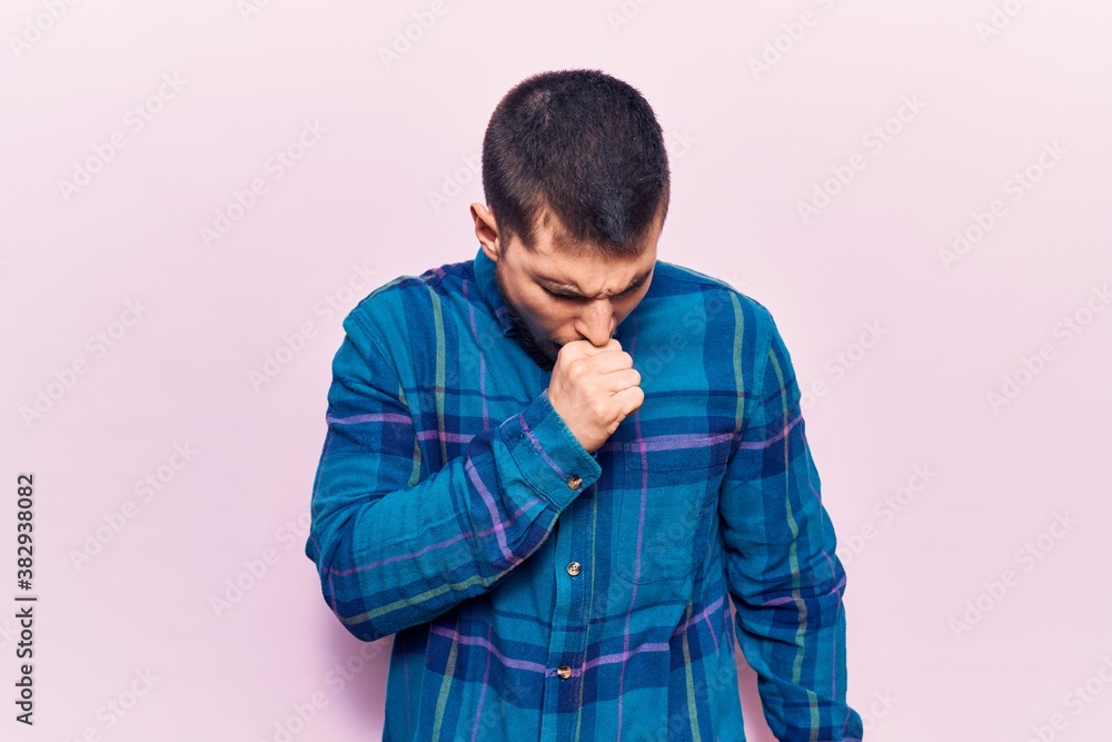 Young handsome man wearing casual shirt feeling unwell and coughing as symptom for cold or bronchitis. health care concept. Young handsome man wearing casual shirt feeling unwell and coughing as symptom for cold or bronchitis. health care concept.