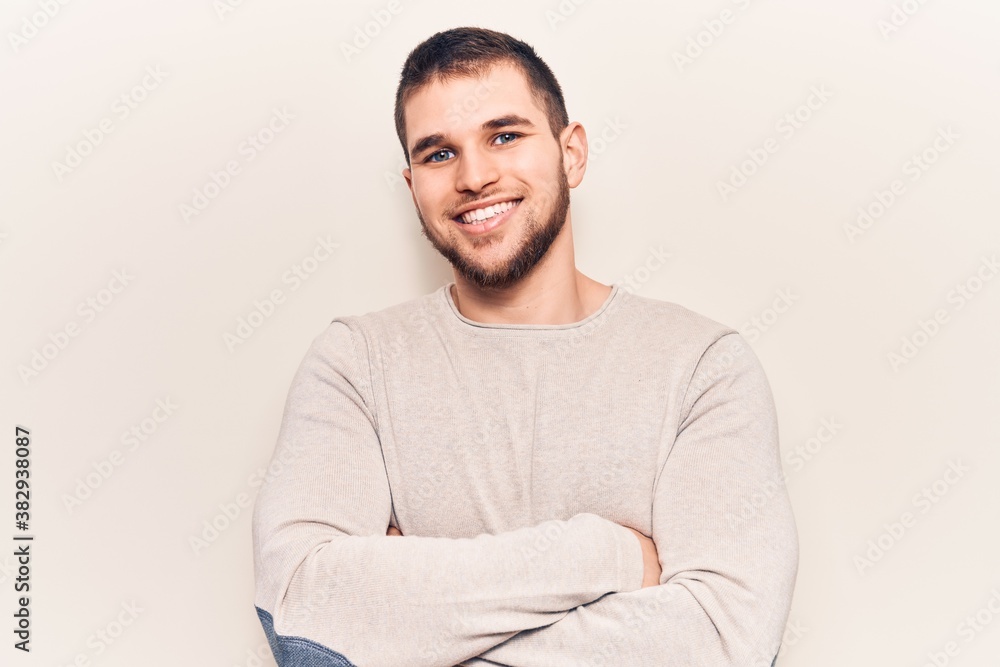 Young handsome man wearing casual sweater happy face smiling with crossed arms looking at the camera. positive person. Young handsome man wearing casual sweater happy face smiling with crossed arms looking at the camera. positive person.