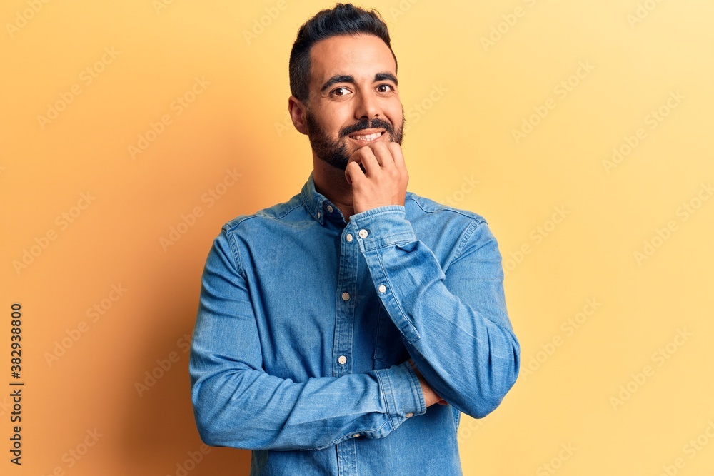 Young hispanic man wearing casual clothes looking confident at the camera with smile with crossed arms and hand raised on chin. thinking positive. Young hispanic man wearing casual clothes looking confident at the camera with smile with crossed arms and hand raised on chin. thinking positive.