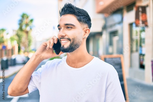Young arab man with serious expression talking on the smartphone at the city.