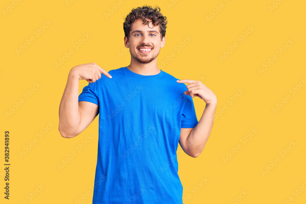 Young handsome man with curly hair wearing casual clothes looking confident with smile on face, pointing oneself with fingers proud and happy. Young handsome man with curly hair wearing casual clothes looking confident with smile on face, pointing oneself with fingers proud and happy.