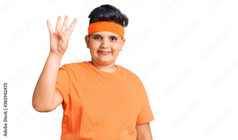 Little boy kid wearing sportswear showing and pointing up with fingers number four while smiling confident and happy. Little boy kid wearing sportswear showing and pointing up with fingers number four while smiling confident and happy.