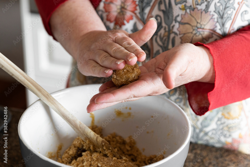 Middle aged women preparing anzac biscuit ball in home kitchen. Middle aged women preparing anzac biscuit ball in home kitchen.