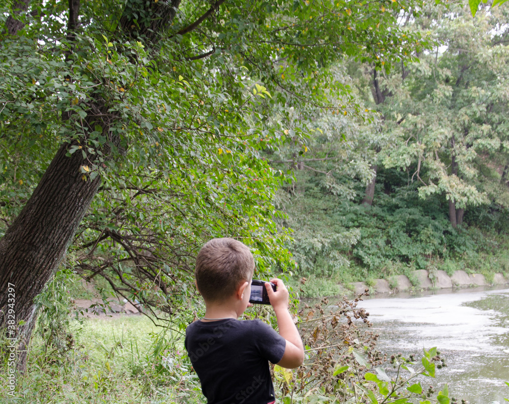 a young boy takes photos with a camera in an autumn Park selective focus a young boy takes photos with a camera in an autumn Park selective focus