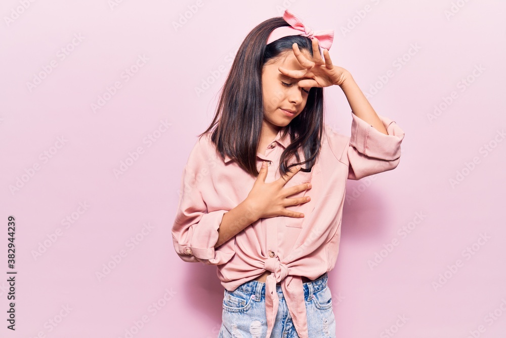 Beautiful child girl wearing casual clothes touching forehead for illness and fever, flu and cold, virus sick Beautiful child girl wearing casual clothes touching forehead for illness and fever, flu and cold, virus sick