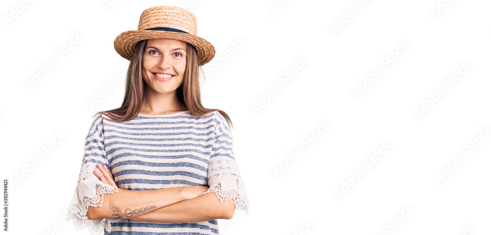 Beautiful caucasian woman wearing summer hat happy face smiling with crossed arms looking at the camera. positive person. Beautiful caucasian woman wearing summer hat happy face smiling with crossed arms looking at the camera. positive person.