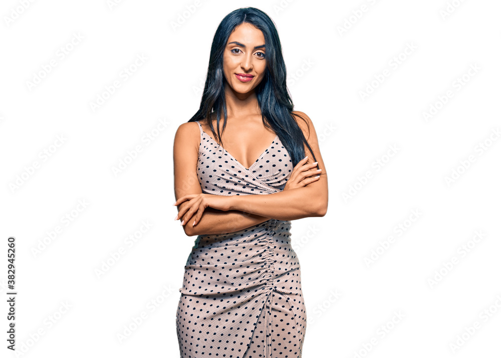 Beautiful hispanic woman wearing summer dress happy face smiling with crossed arms looking at the camera. positive person. Beautiful hispanic woman wearing summer dress happy face smiling with crossed arms looking at the camera. positive person.