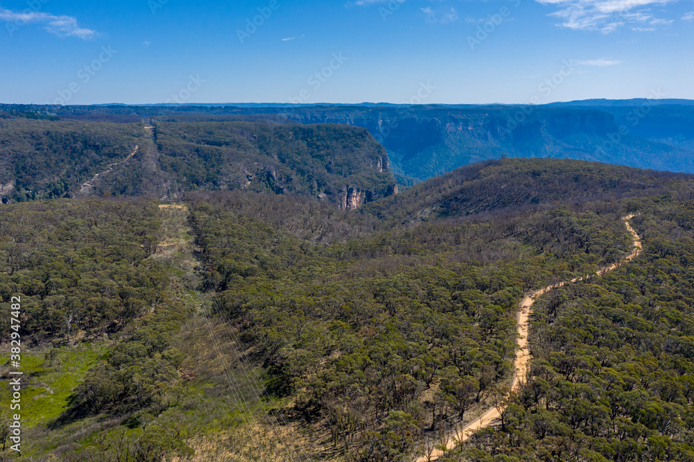 Aerial view of a dirt track running through forest in regional New South Wales in Australia