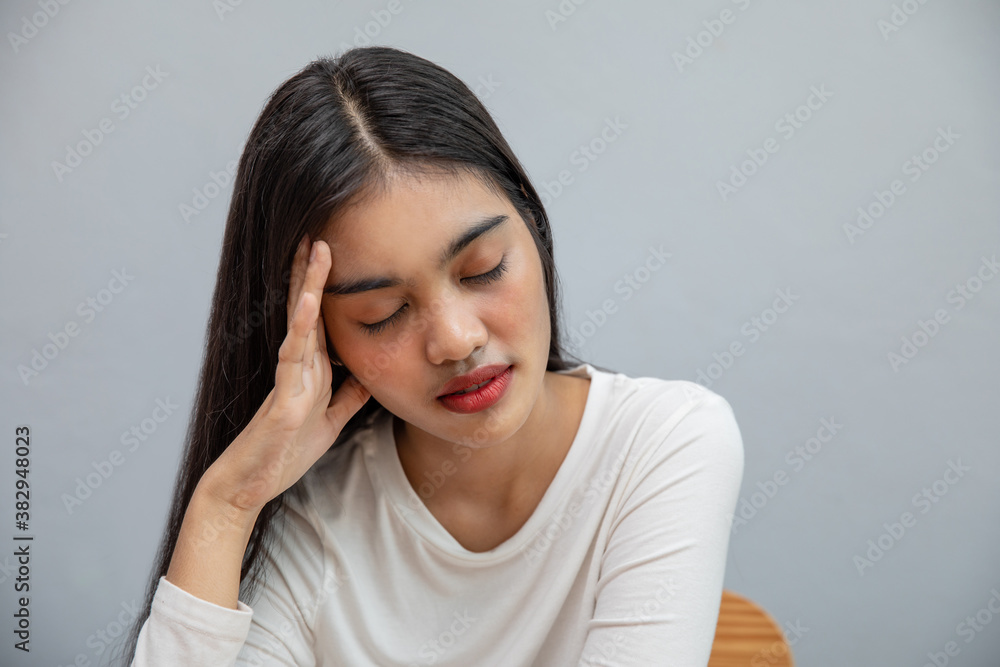 Sick Asian woman sneezing and Headache at home, she uses medicine mask Sick Asian woman sneezing and Headache at home, she uses medicine mask
