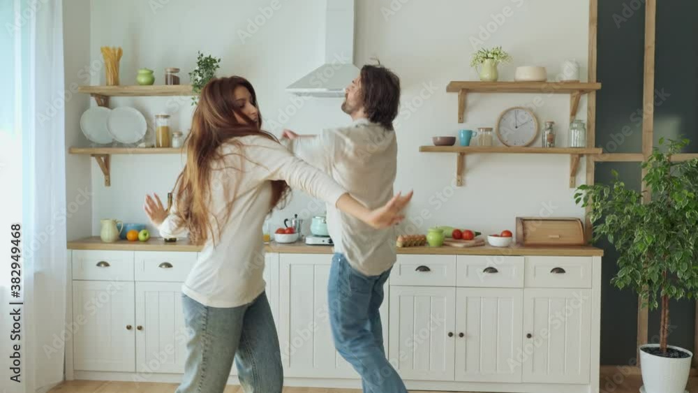 Lovely Couple Having a Fun Together While Dancing at the Bright Kitchen. Lovely Couple Having a Fun Together While Dancing at the Bright Kitchen.