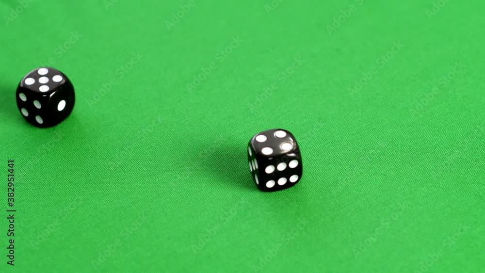 Male hand throwing double dice five and four on green background. Player rolling dice cubes on green game table. Gambling game in casino Male hand throwing double dice five and four on green background. Player rolling dice cubes on green game table. Gambling game in casino