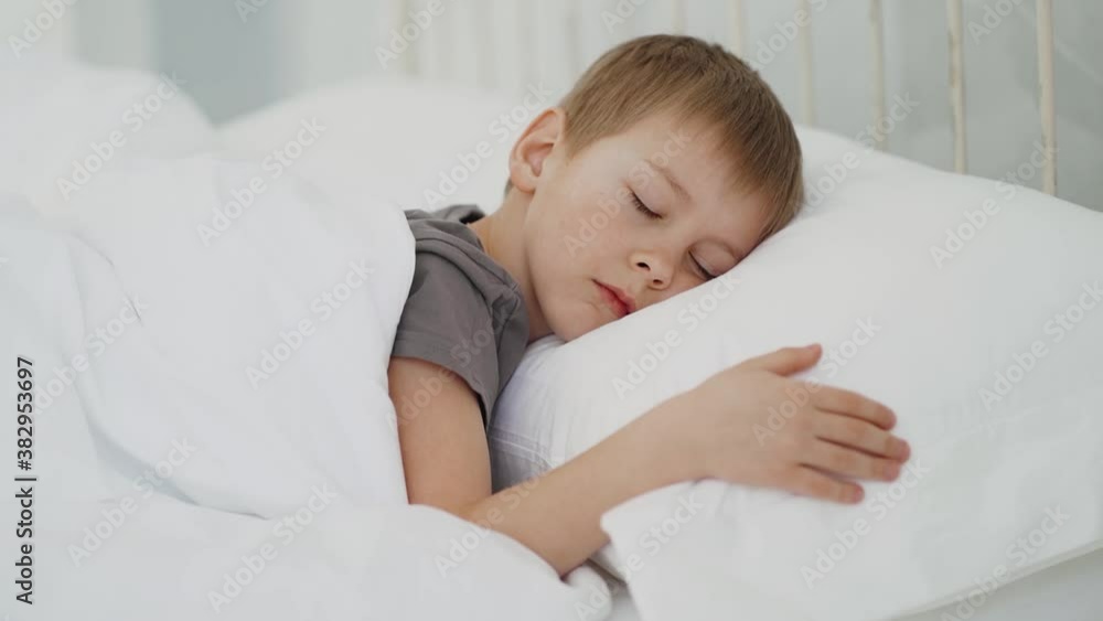 A boy lying in bed at night, restless sleep and insomnia concept A boy lying in bed at night, restless sleep and insomnia concept