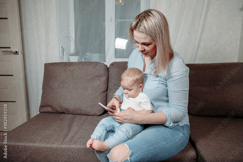 mother and baby are looking to play tablet computer or smart phone at home. mother and baby are looking to play tablet computer or smart phone at home.
