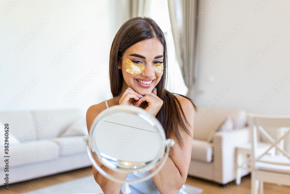 Beauty portrait of young woman with wrinkles and a golden patch under eyes. Collagen mask and spa concept. Copy space. Summer skin care. Looking in the mirror Beauty portrait of young woman with wrinkles and a golden patch under eyes. Collagen mask and spa concept. Copy space. Summer skin care. Looking in the mirror