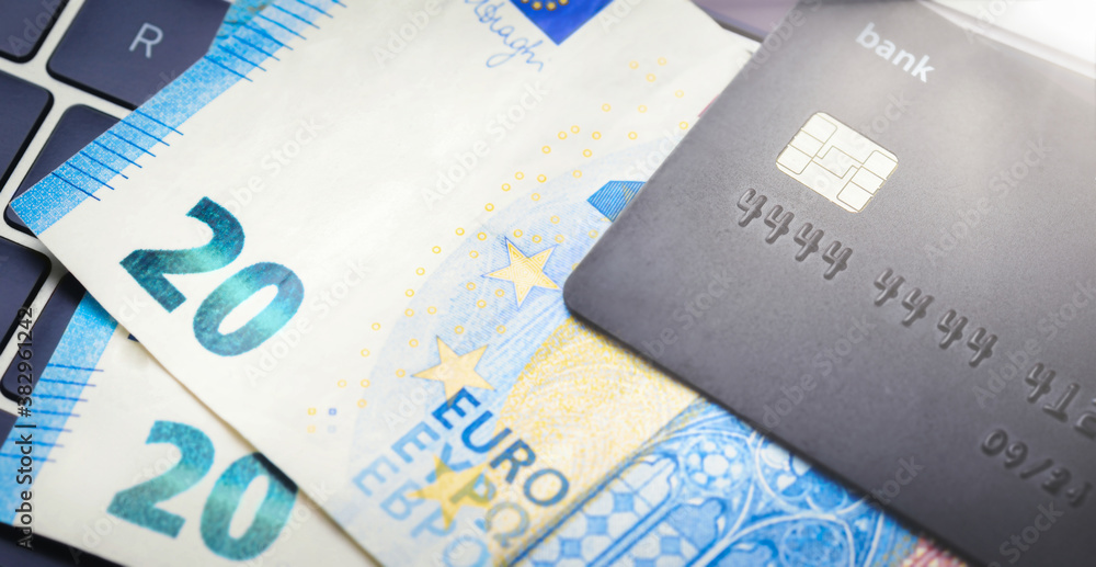 Online shopping concept. Credit card with banknotes on the keyboard top view Online shopping concept. Credit card with banknotes on the keyboard top view