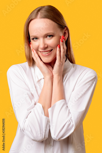 Female beauty. Natural skincare. Face treatment. Health wellness. Cheerful woman in white shirt smiling isolated on yellow background.