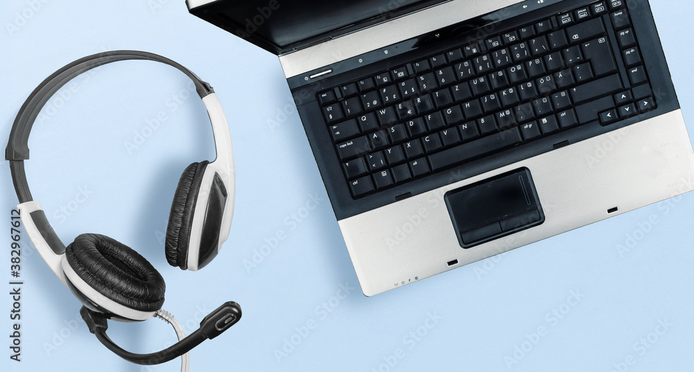 Laptop and Headset on blue isolated background Laptop and Headset on blue isolated background