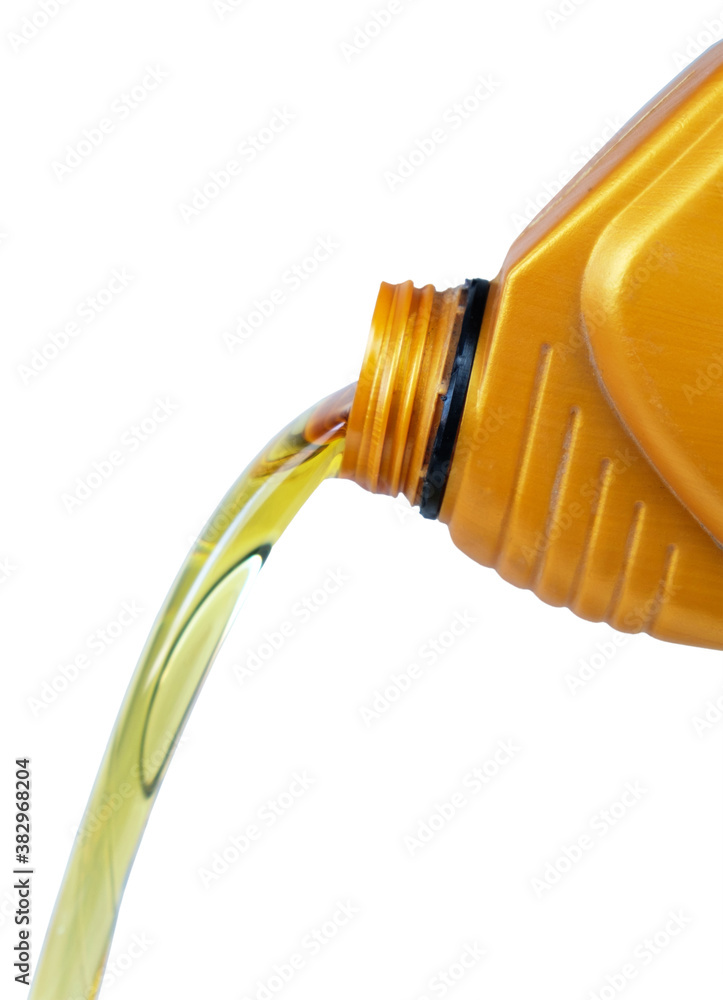 Engine motor oil pouring from a plastic container, isolated on a white background Engine motor oil pouring from a plastic container, isolated on a white background
